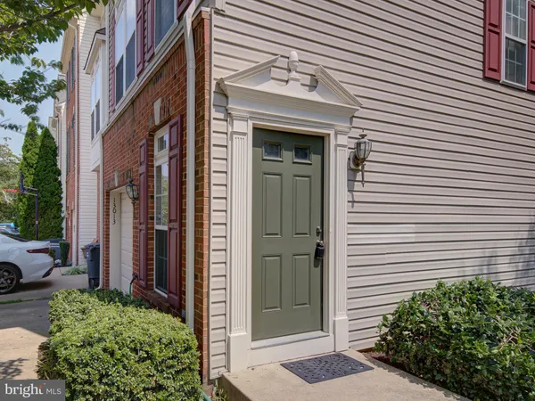 a view of a brick house with a door and a flower plants