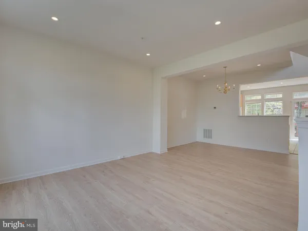 an empty room with a window and wooden floor