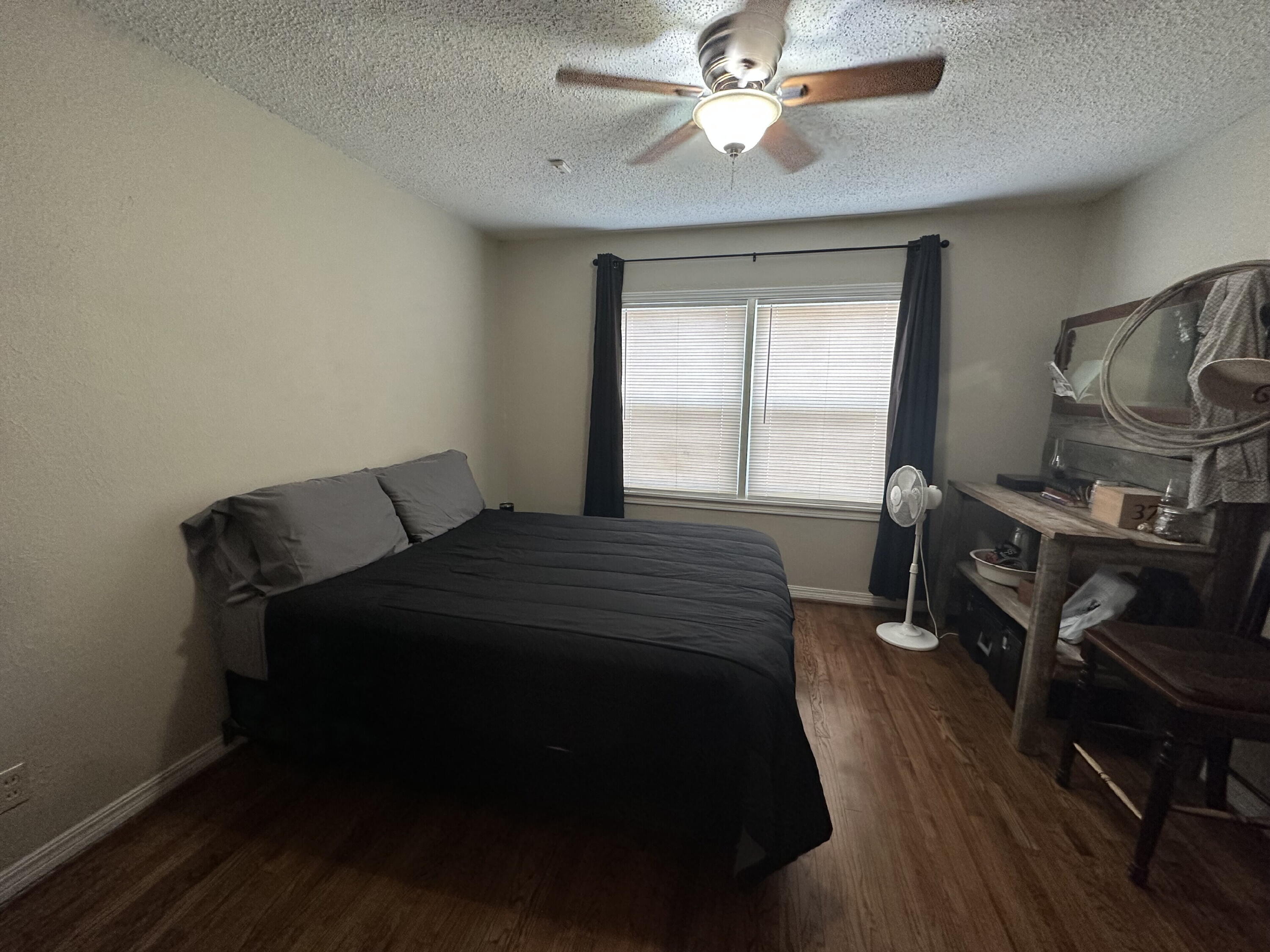 3214 32nd Street Lubbock, TX 79410 - Photo 12 of 17 a bedroom with a bed and wooden floor