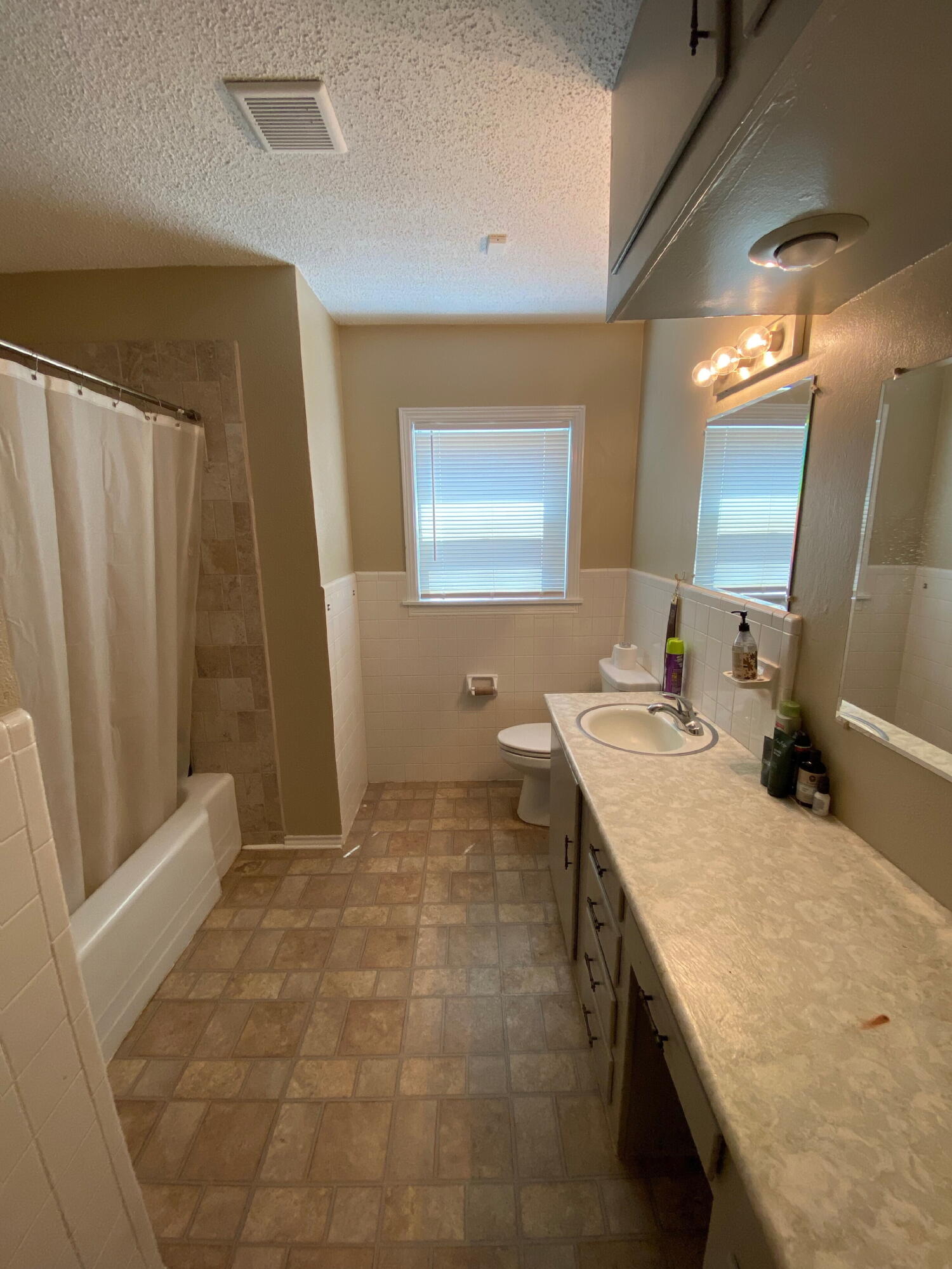 3214 32nd Street Lubbock, TX 79410 - Photo 13 of 17 a bathroom with a sink a mirror and a shower