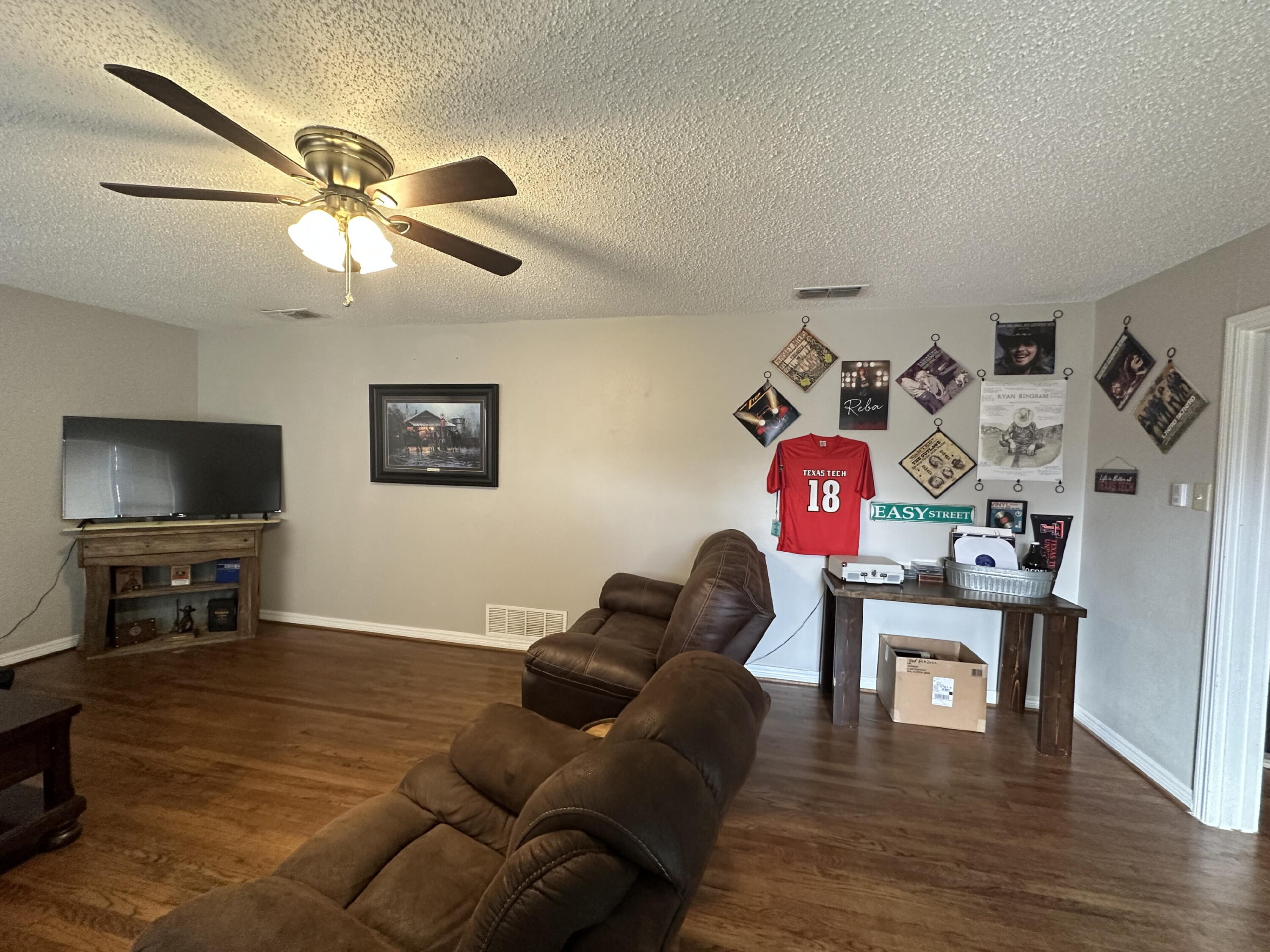 3214 32nd Street Lubbock, TX 79410 - Photo 4 of 17 a living room with furniture and a flat screen tv with wooden floor