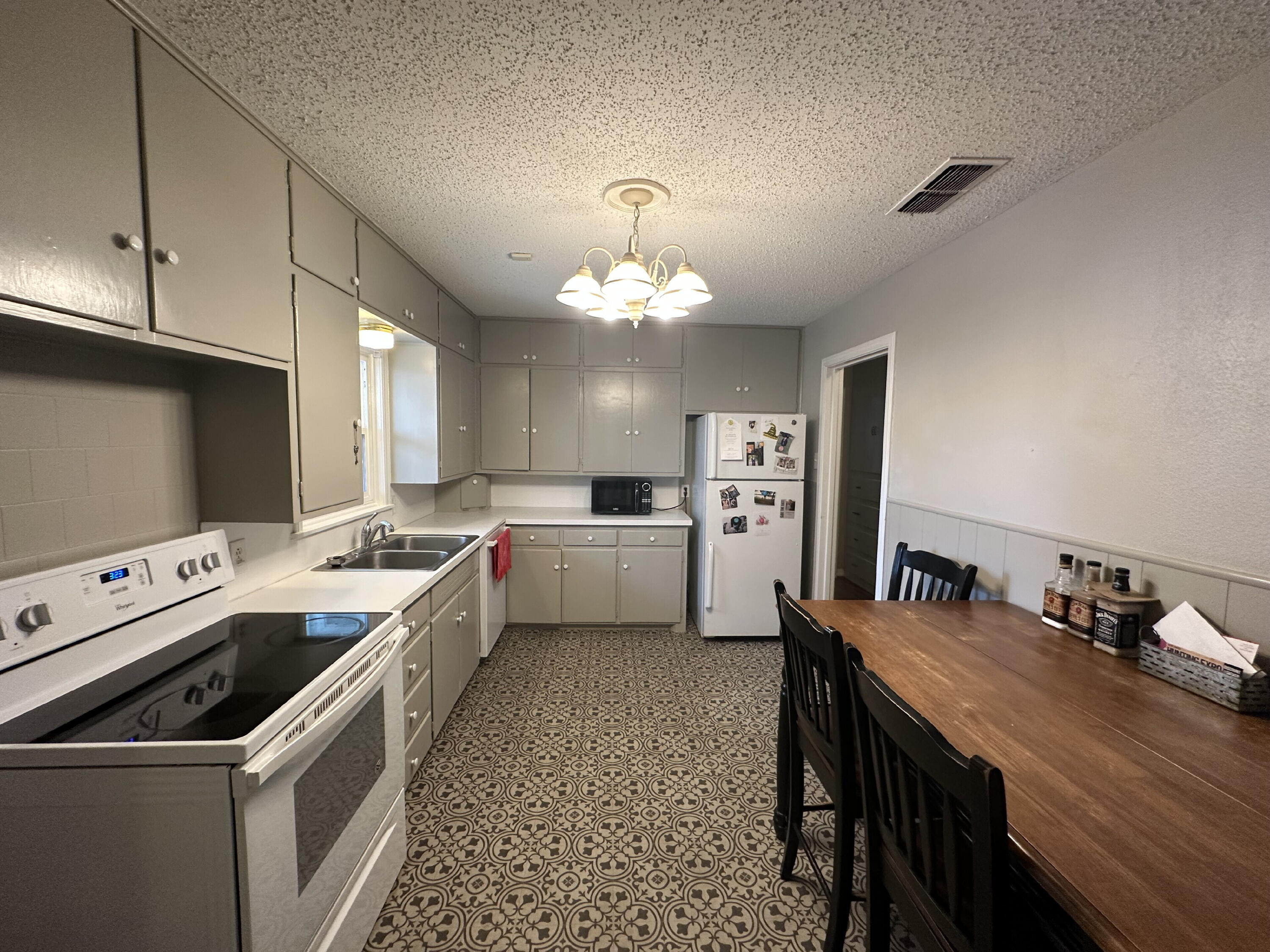 3214 32nd Street Lubbock, TX 79410 - Photo 5 of 17 a kitchen that has a sink a stove oven a counter space and cabinets