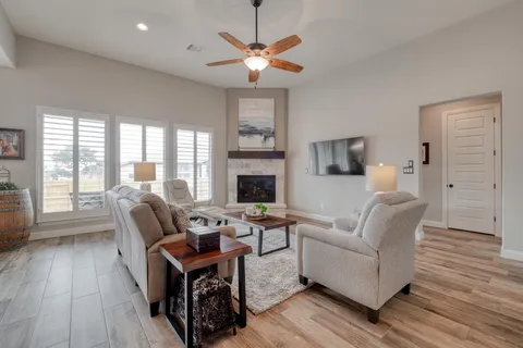 a living room with furniture a fireplace and a floor to ceiling window