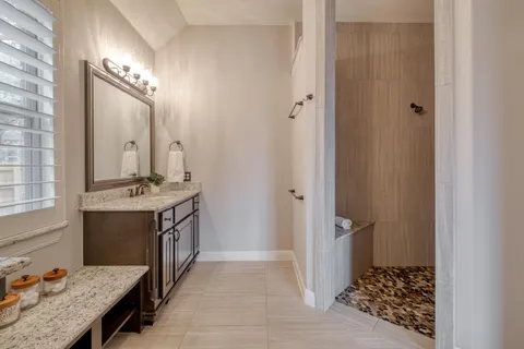 a bathroom with a granite countertop sink and a mirror
