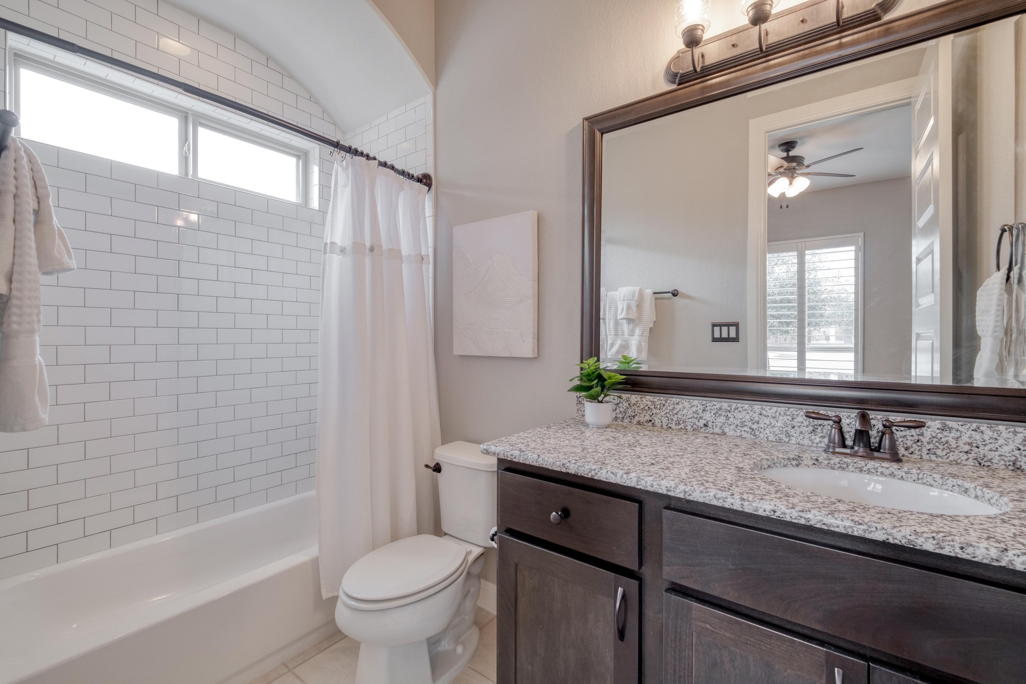 3836 Kyler Glen Road Round Rock, TX 78681 - Photo 28 of 38 a bathroom with a granite countertop sink a toilet a mirror a vanity and bathtub