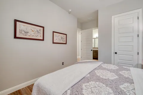 a bedroom with a bed and painting on the wall