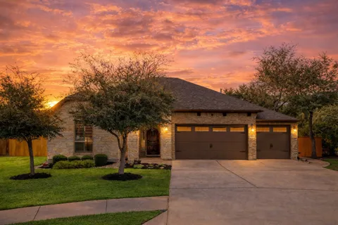front view of a house with a yard and garage