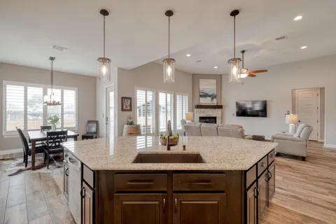 a view of a dining room and livingroom with furniture wooden floor a chandelier