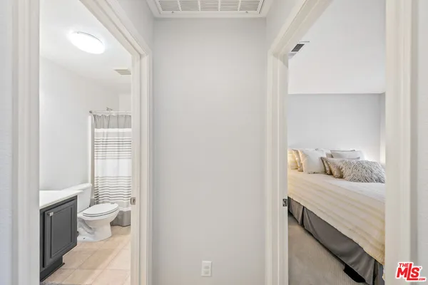 a bedroom with a bed a lamp and a flat screen tv