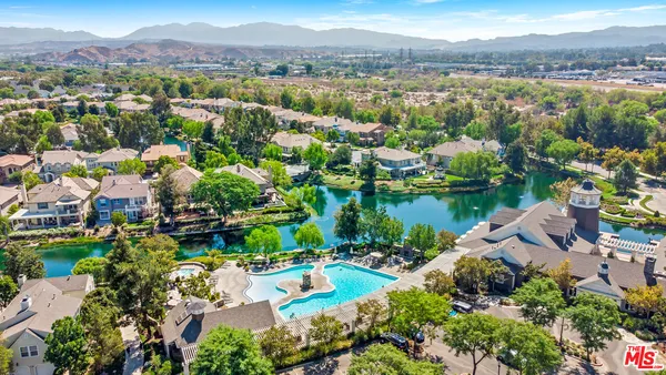 an aerial view of a house with a yard and lake view in back