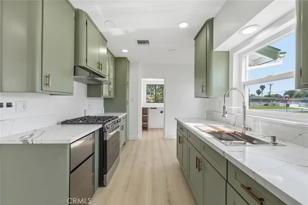 a kitchen with stainless steel appliances granite countertop a sink stove and cabinets