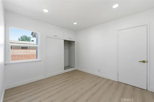 an empty room with wooden floor and window
