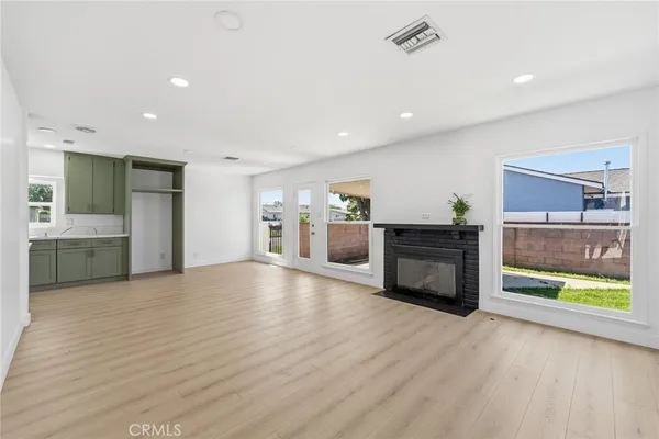 a view of a kitchen with a sink oven cabinets and front door