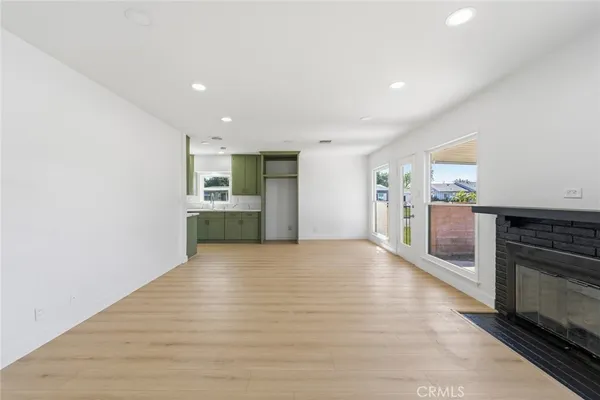 a view of a kitchen with a sink and an empty room