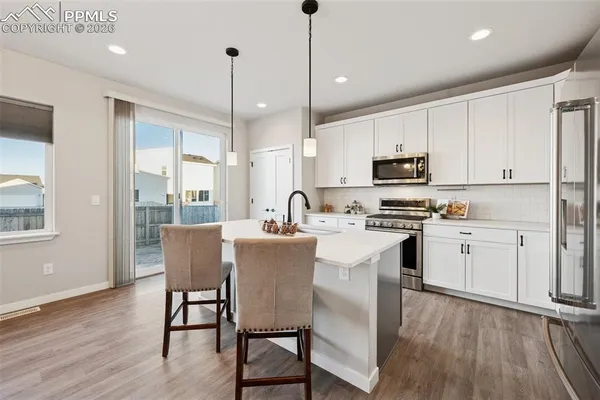 a kitchen with microwave a sink cabinets and wooden floor