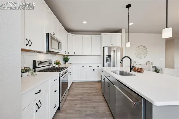 a kitchen with stainless steel appliances sink a stove and cabinets