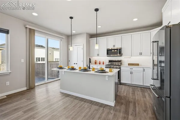 a kitchen with stainless steel appliances a refrigerator sink and microwave