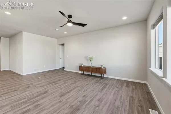 an empty room with wooden floor and windows