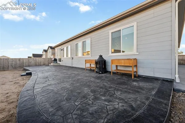 a backyard of a house with barbeque oven fire pit and table and chairs