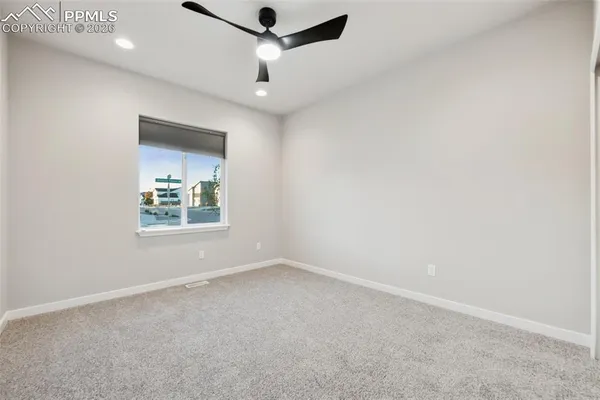 an empty room with a ceiling fan and shower