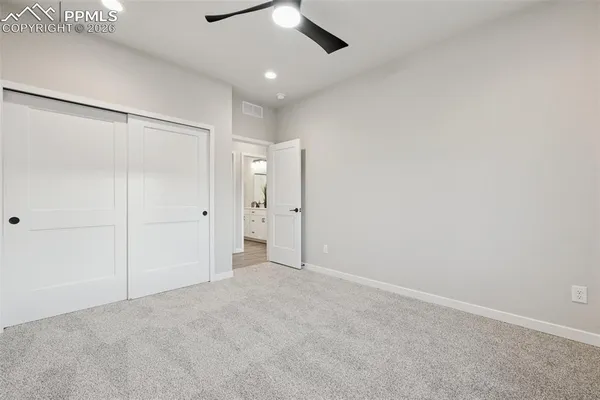 an empty room with windows and ceiling fan