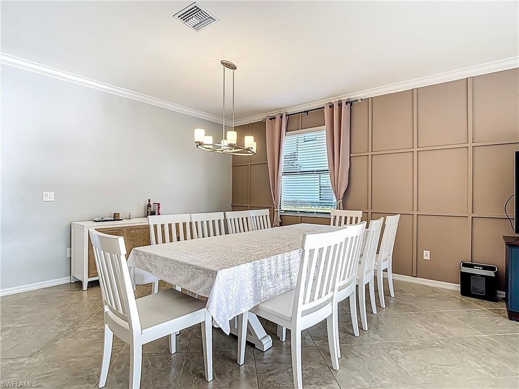 19890 Beverly Park Road Estero, FL 33928 - Photo 15 of 38 Dining space with ornamental molding and a chandelier