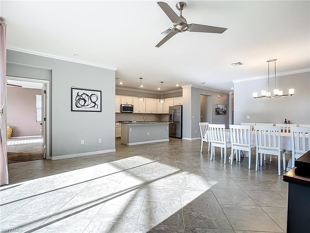 19890 Beverly Park Road Estero, FL 33928 - Photo 16 of 38 Living room with ceiling fan, crown molding, recessed lighting, and a chandelier