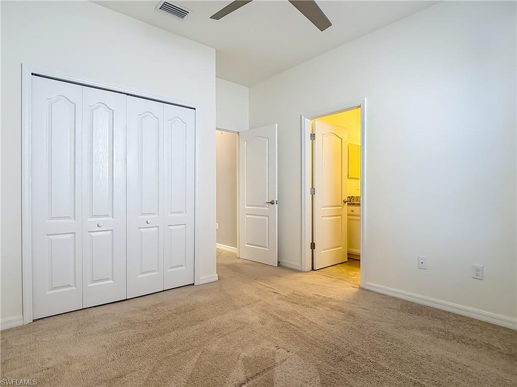 19890 Beverly Park Road Estero, FL 33928 - Photo 20 of 38 Unfurnished bedroom featuring light carpet, ceiling fan, a closet, and ensuite bath