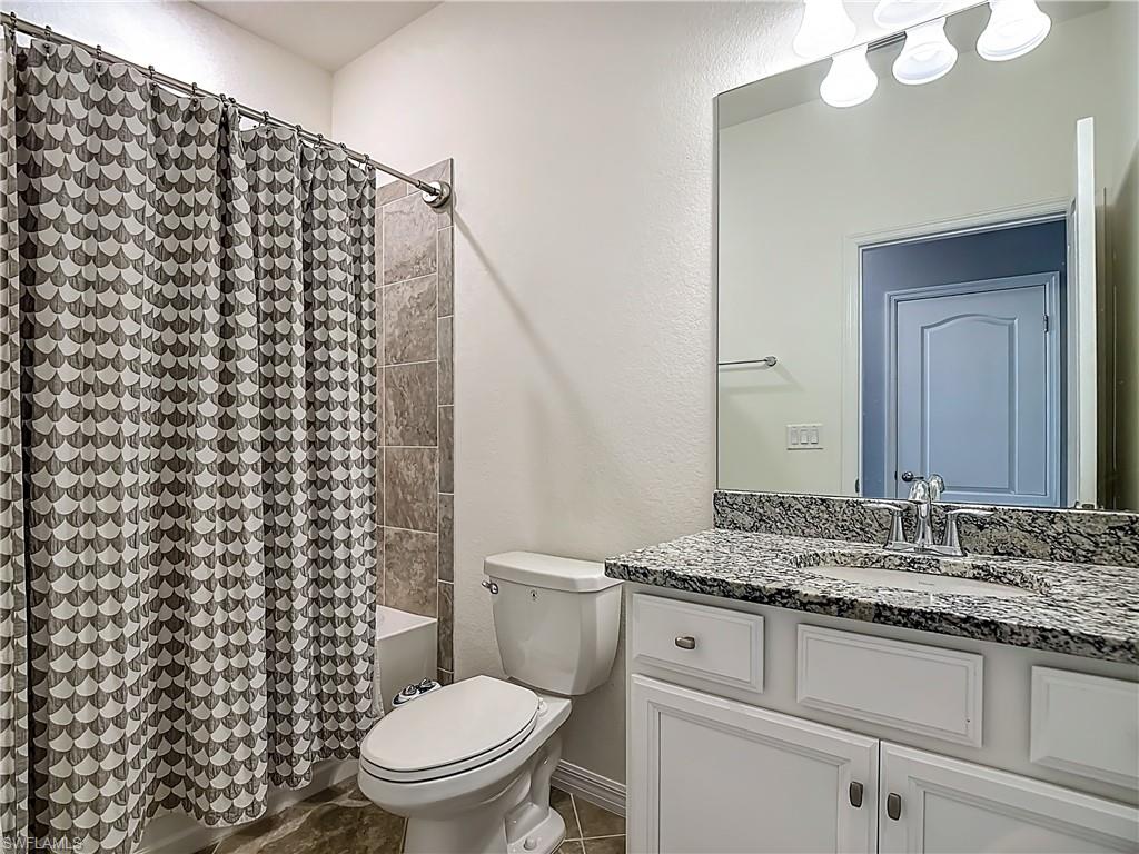 19890 Beverly Park Road Estero, FL 33928 - Photo 23 of 38 Full bath featuring vanity, shower / bath combination with curtain, and a textured wall