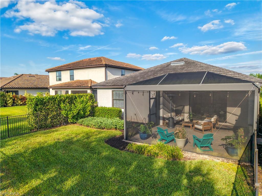 19890 Beverly Park Road Estero, FL 33928 - Photo 27 of 38 Rear view of property with stucco siding, a sunroom, a tile roof, outdoor lounge area, and a lanai