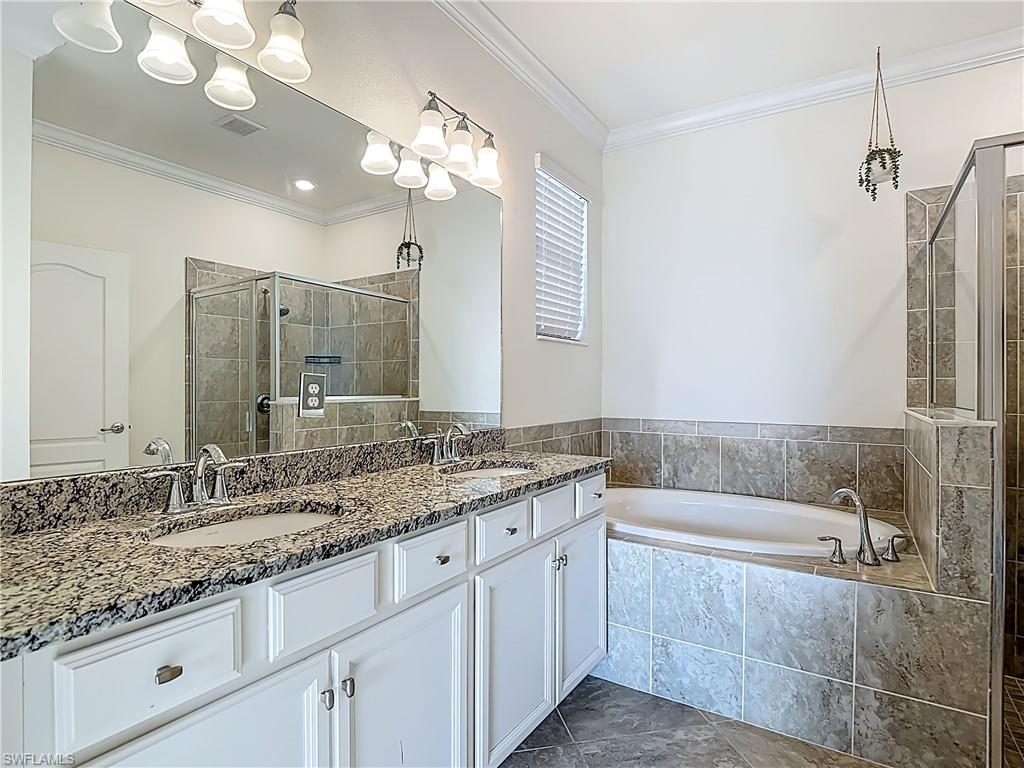 19890 Beverly Park Road Estero, FL 33928 - Photo 7 of 38 Bathroom with a bath, double vanity, and a stall shower