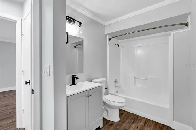 a bathroom with a bathtub shower sink vanity and a toilet