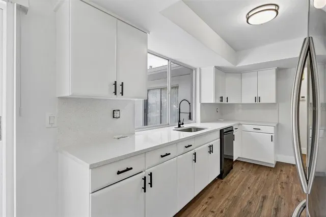 a kitchen with cabinets appliances and a sink