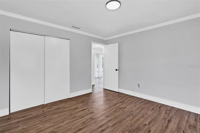 a view of an empty room with wooden floor