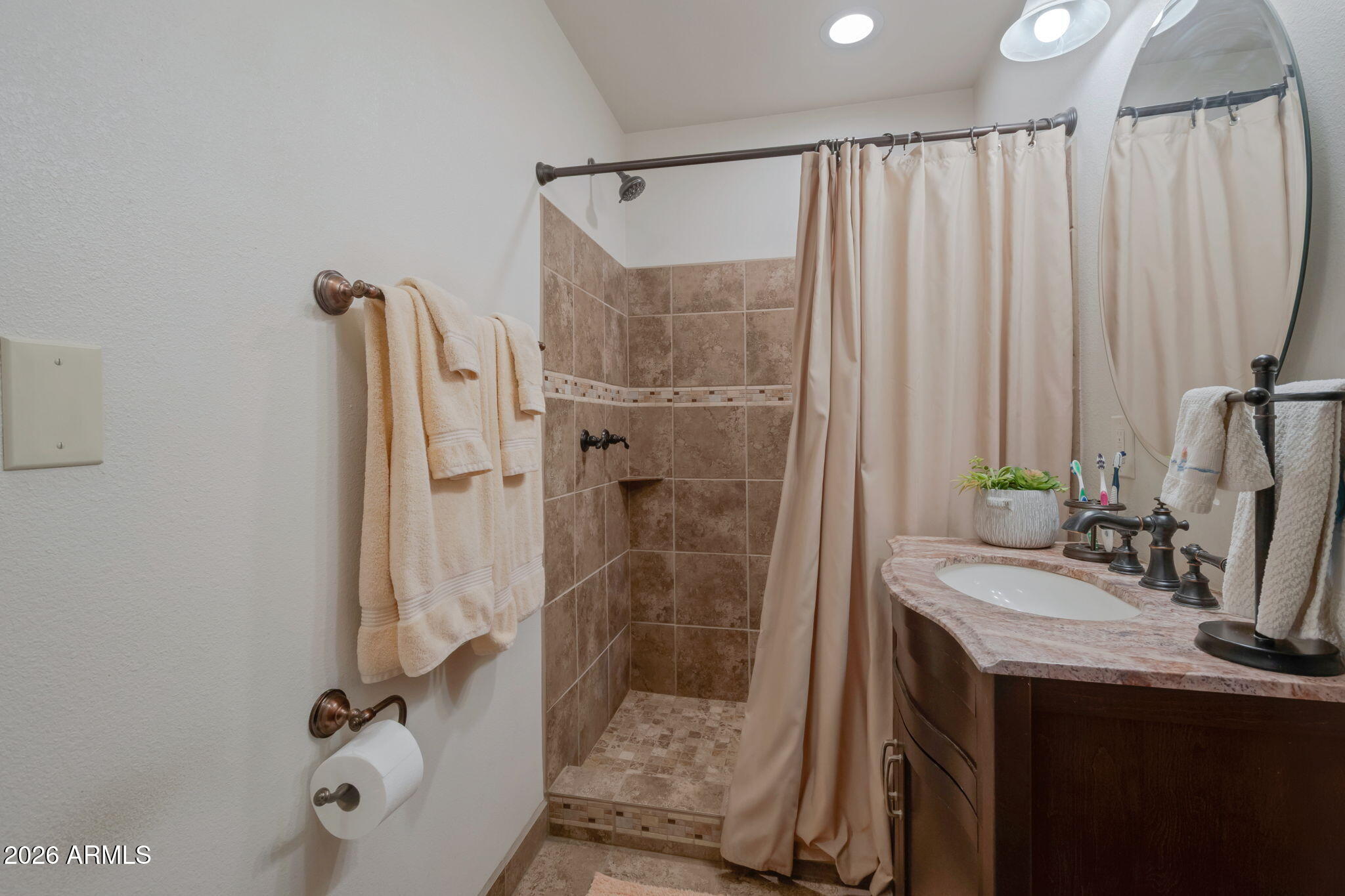 8865 North Page Road Florence, AZ 85132 - Photo 11 of 15 a bathroom with a sink a mirror and a shower