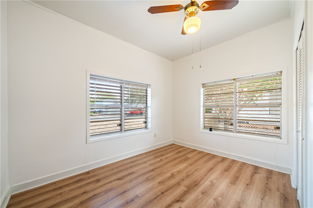1205 10th Street Corpus Christi, TX 78404 - Photo 17 of 38 a view of an empty room with a window and wooden floor