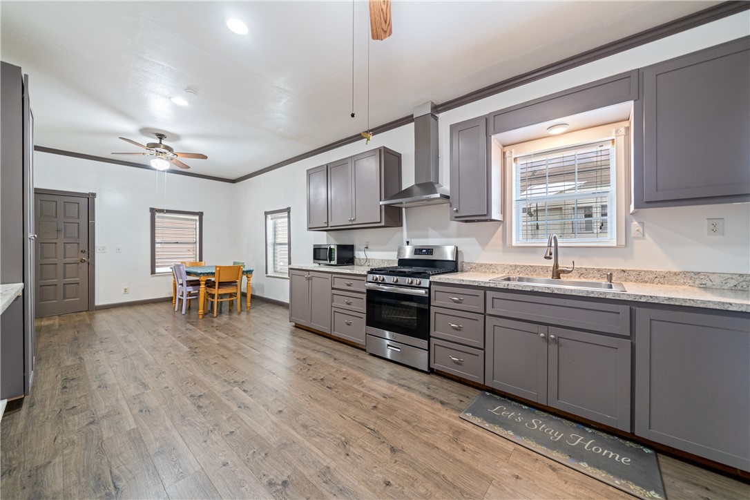1205 10th Street Corpus Christi, TX 78404 - Photo 23 of 38 a kitchen with stainless steel appliances granite countertop wooden cabinets a dining table and chairs