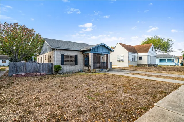 a front view of a house with a yard and wooden fence