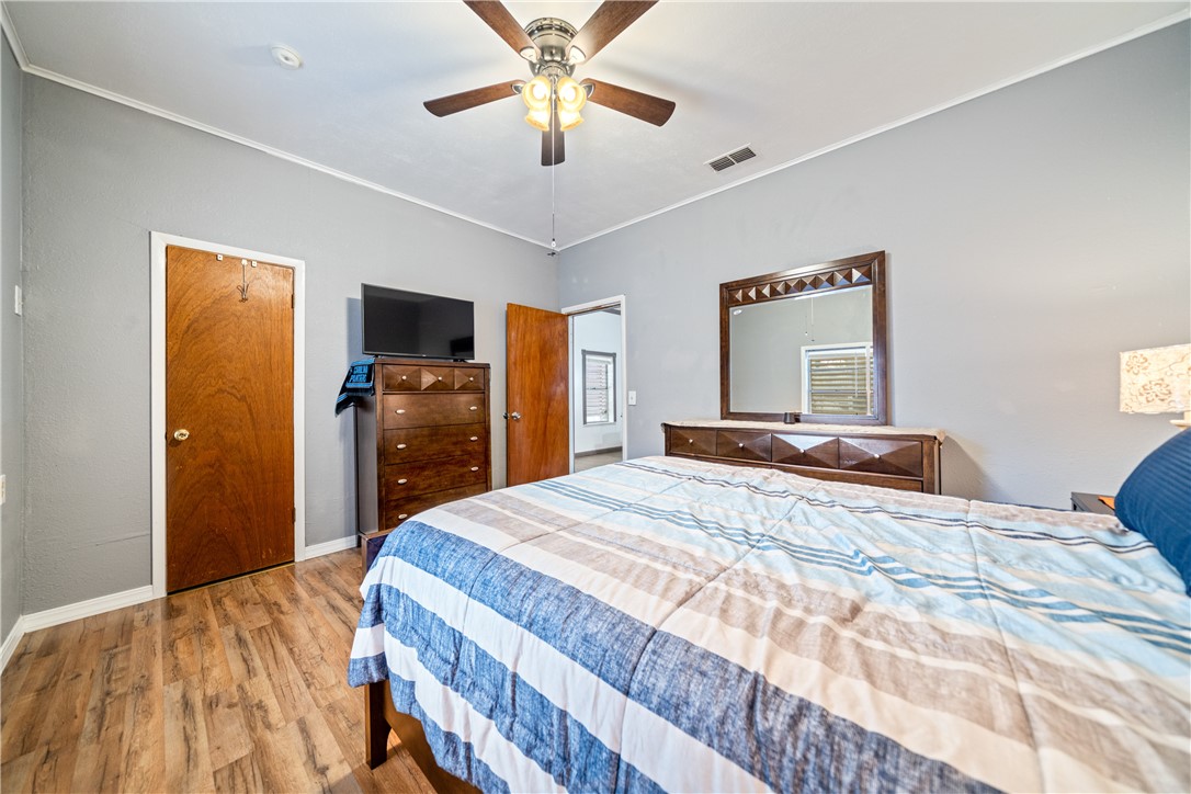 1205 10th Street Corpus Christi, TX 78404 - Photo 33 of 38 a bedroom with a bed and a flat tv screen on dresser