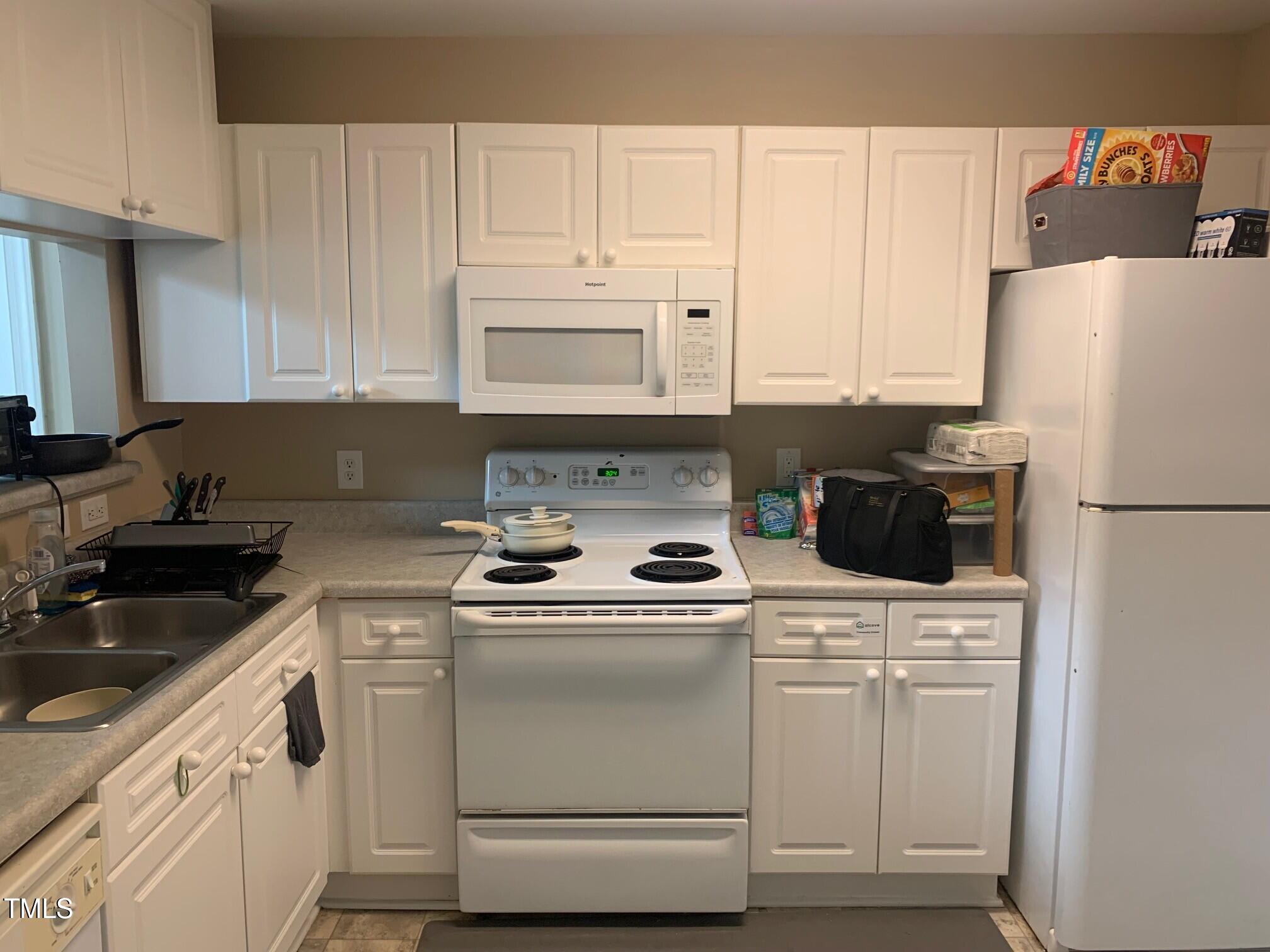 929 Morreene Road, Unit D34 Durham, NC 27705 - Photo 4 of 5 a kitchen with white cabinets and white appliances