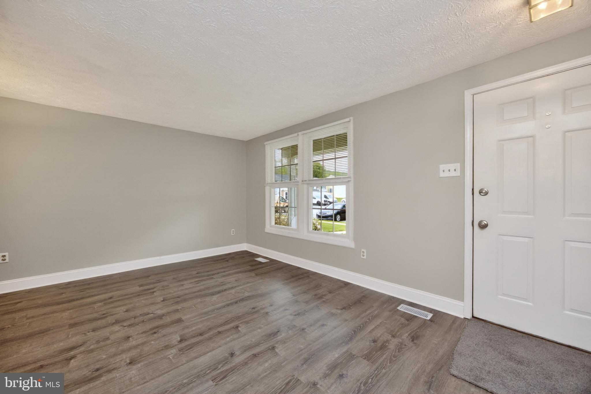 348 Barclay Street Coatesville, PA 19320 - Photo 4 of 28 a view of an empty room with wooden floor and a window