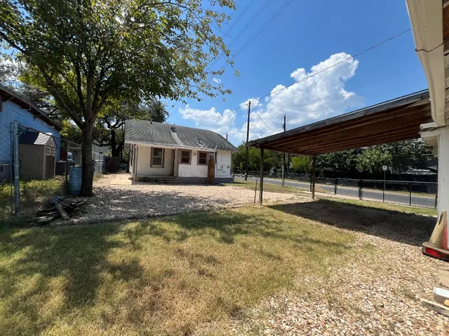 a view of a house with backyard and sitting area