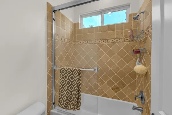 a bathroom with a tub a mirror and a shower