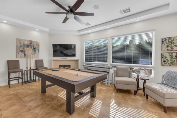 a kitchen with stainless steel appliances granite countertop a stove a sink a refrigerator a dining table and chairs