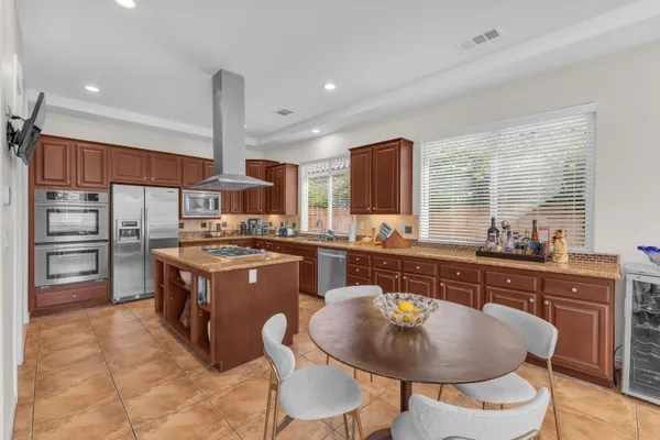 a kitchen with stainless steel appliances granite countertop a stove refrigerator and cabinets