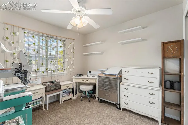 a view of a workspace with furniture and a window