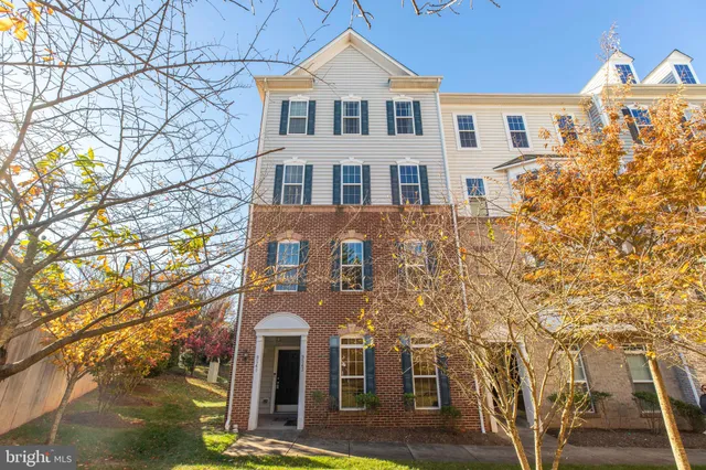 a front view of a house with large trees
