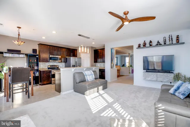 a living room with furniture a kitchen view and a fireplace