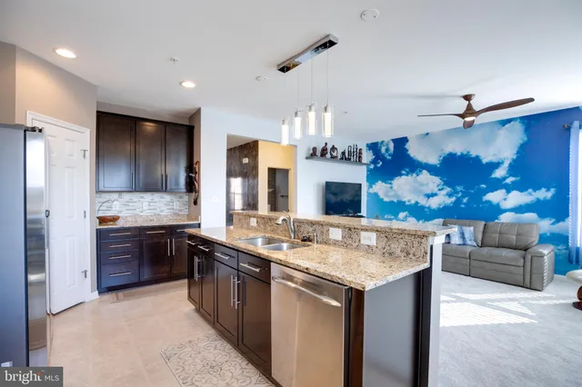 a kitchen with stainless steel appliances granite countertop a sink and a stove