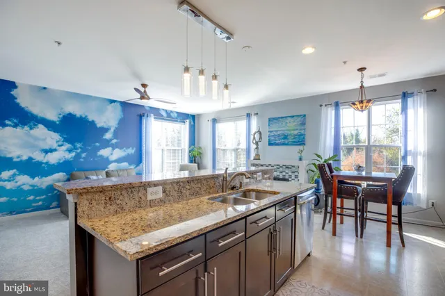 a living room with granite countertop kitchen island furniture and a chandelier